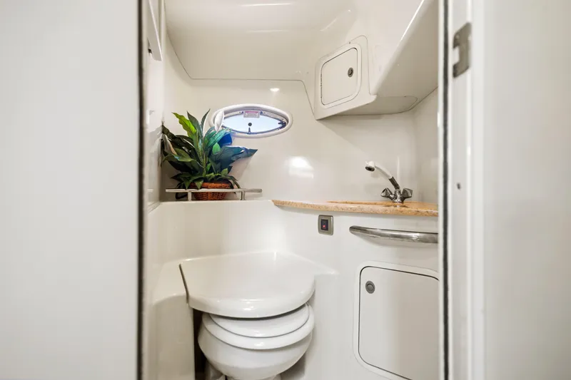 Slide: The Image of 2004 Sea Ray 420 Sundancer bathroom with sink, toilet, and porthole window. - 36