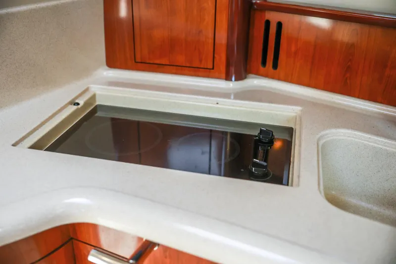 Slide: The Image of 2004 Sea Ray 420 Sundancer kitchen with stove and wooden cabinetry. - 38