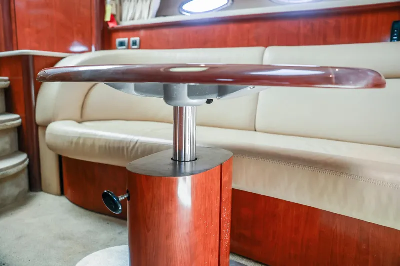 Slide: The Image of Interior of 2004 Sea Ray 420 Sundancer with wooden table and beige seating. - 44