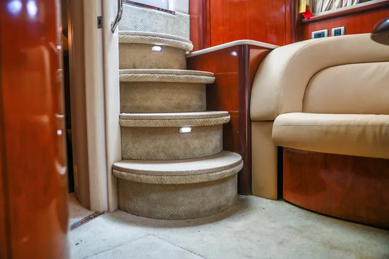 Slide: The Image of Interior of 2004 Sea Ray 420 Sundancer yacht with carpeted stairs and leather seating. - 48