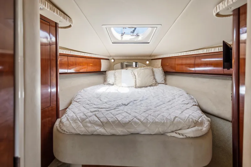 Slide: The Image of Luxurious 2004 Sea Ray 420 Sundancer cabin with elegant wood paneling and plush bedding. - 49
