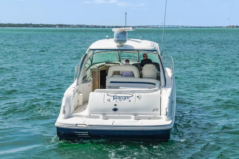 Slide: The Image of 2004 Sea Ray 420 Sundancer cruising on open water, rear view. - 5