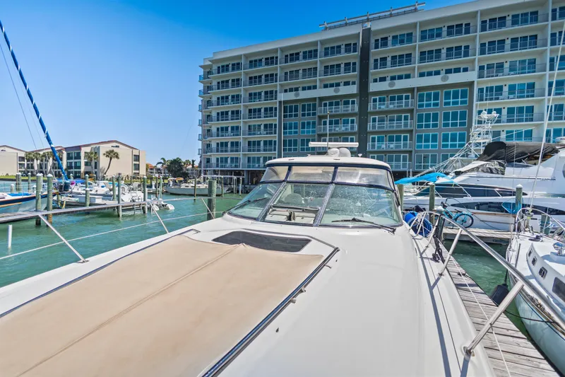 Slide: The Image of 2004 Sea Ray 420 Sundancer yacht docked at marina with modern building backdrop. - 55