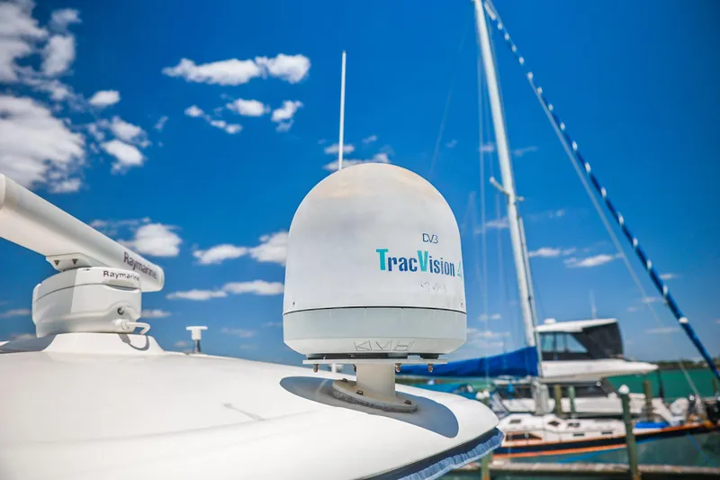 Slide: The Image of Radar and TracVision equipment on a 2004 Sea Ray 420 Sundancer yacht under a clear blue sky. - 58