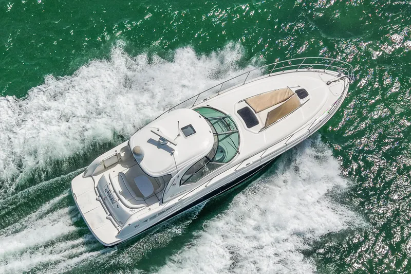Slide: The Image of 2004 Sea Ray 420 Sundancer cruising on vibrant green water, aerial view. - 9