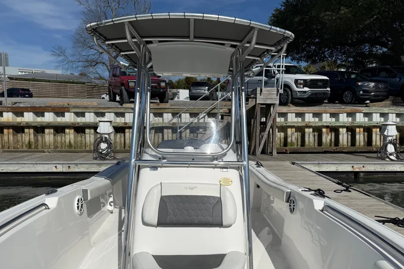 Slide: The Image of 2017 Tidewater 220 CC Adventure boat docked at marina with vehicles in background. - 15