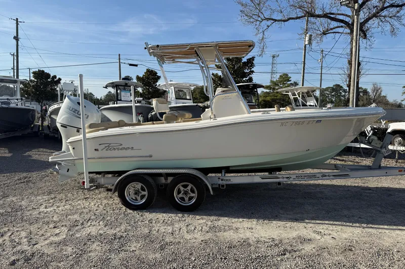 Slide: The Image of 2021 Pioneer 202 Islander boat on trailer, parked outdoors under clear sky. - 13