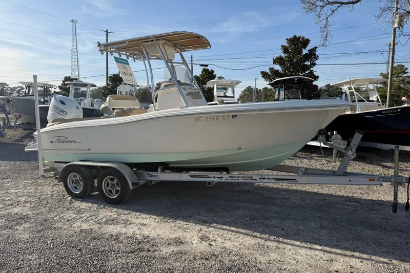 Slide: The Image of 2021 Pioneer 202 Islander boat on trailer, displayed outdoors. - 14