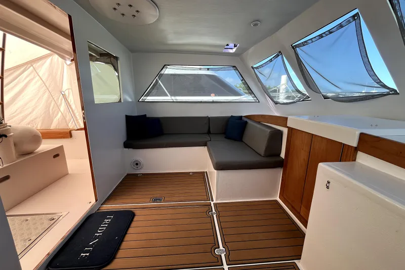Slide: The Image of Interior of a 1982 Torres Boat Mfg 43, featuring seating and wooden flooring. - 14