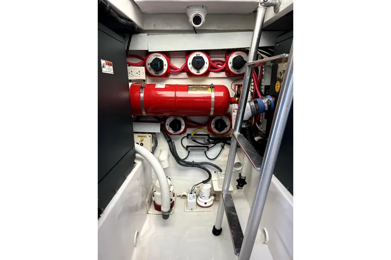 Slide: The Image of Engine room of 1982 Torres Boat Mfg 43, featuring red fire extinguisher and control panels. - 22