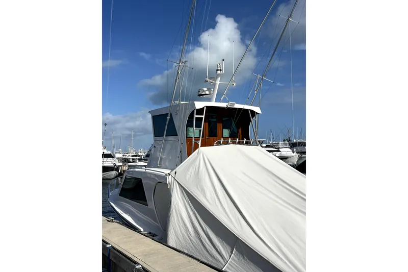 Slide: The Image of 1982 Torres Boat Mfg 43 docked, covered with tarp, under clear blue sky. - 46