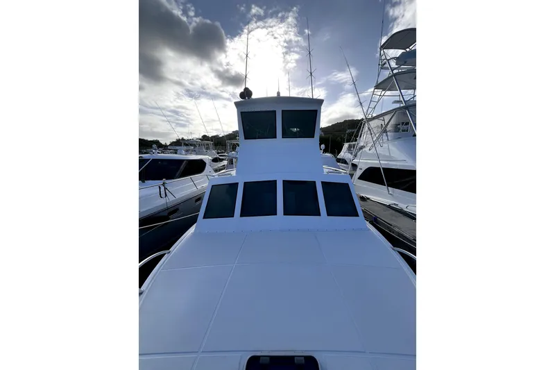 Slide: The Image of 1982 Torres Boat Mfg 43 docked, showcasing sleek design and spacious deck under cloudy sky. - 48