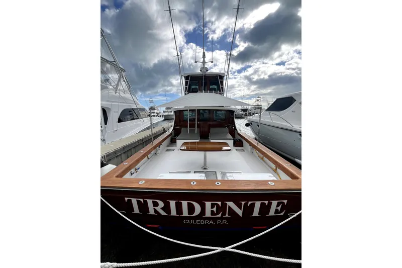 Slide: The Image of 1982 Torres Boat Mfg 43 docked, named "Tridente," with wooden accents and cloudy sky backdrop. - 51