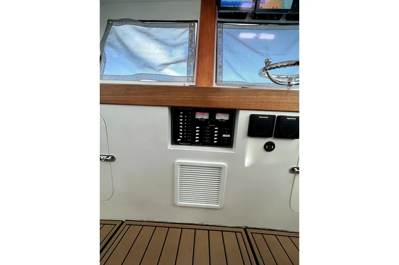 Slide: The Image of Captain's chair and control panel on 1982 Torres Boat Mfg 43, featuring wood accents and large windows. - 37