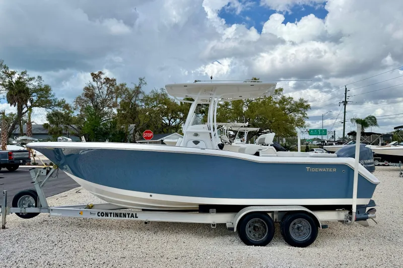 The Image of 2014 Tidewater 230 LXF boat on trailer, parked outdoors under cloudy sky. - 0