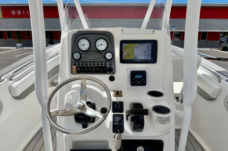 Slide: The Image of 2014 Tidewater 230 LXF boat dashboard with steering wheel and navigation instruments. - 19