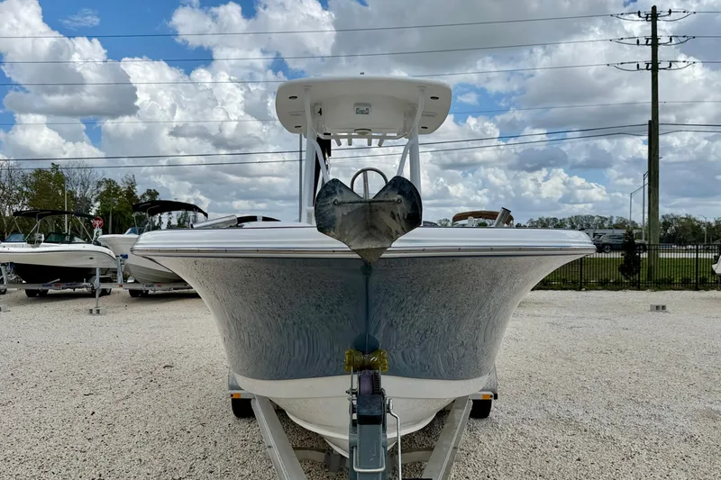 Slide: The Image of 2014 Tidewater 230 LXF boat on trailer, displayed outdoors under a cloudy sky. - 2