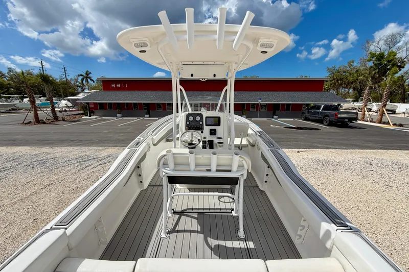 Slide: The Image of 2014 Tidewater 230 LXF boat with center console, parked under a clear blue sky. - 24