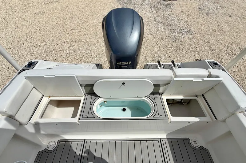 Slide: The Image of 2014 Tidewater 230 LXF boat with open storage compartments and outboard motor. - 26