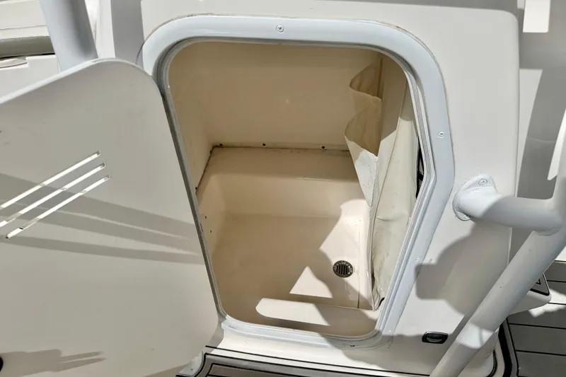 Slide: The Image of Open storage compartment on a 2014 Tidewater 230 LXF boat, featuring a drain. - 28