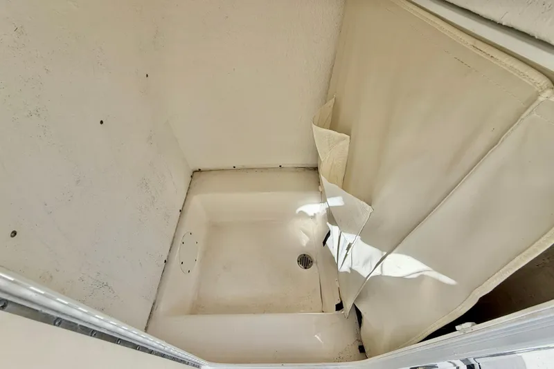 Slide: The Image of 2014 Tidewater 230 LXF boat interior compartment with drain and curtain. - 29