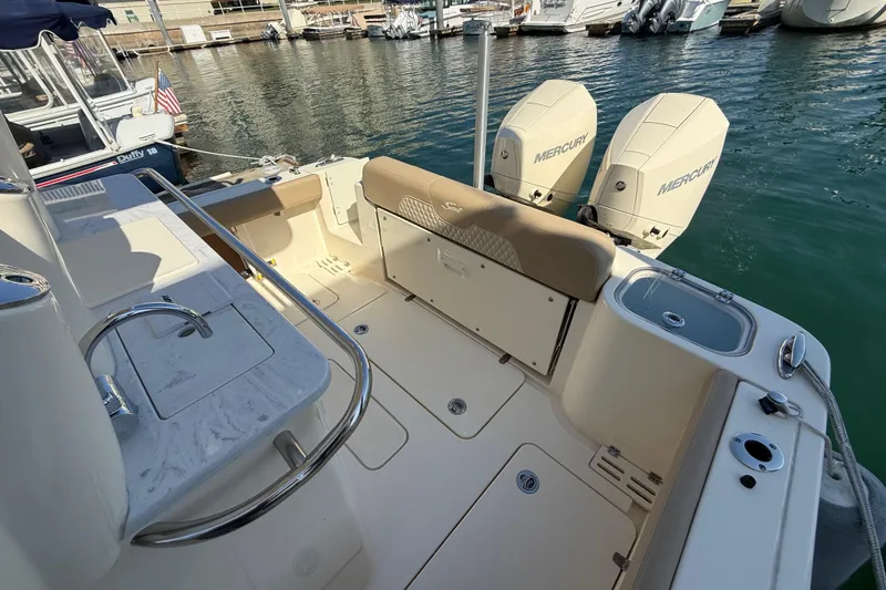 Slide: The Image of 2024 Scout 260 LXF boat interior with dual Mercury engines at marina. - 11