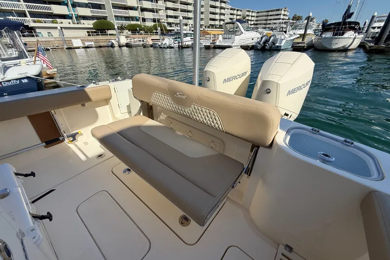 Slide: The Image of 2024 Scout 260 LXF boat interior with seating and Mercury engines at marina. - 12
