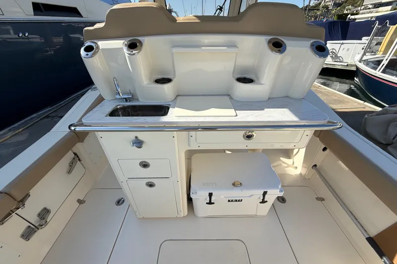 Slide: The Image of 2024 Scout 260 LXF boat interior with sink, storage, and Yeti cooler. - 15