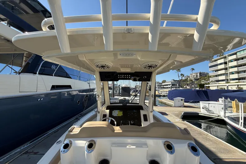 Slide: The Image of 2024 Scout 260 LXF boat interior with helm, docked at marina. - 16