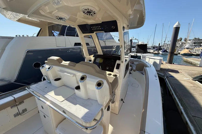 Slide: The Image of 2024 Scout 260 LXF boat interior at marina, featuring helm and seating area. - 17