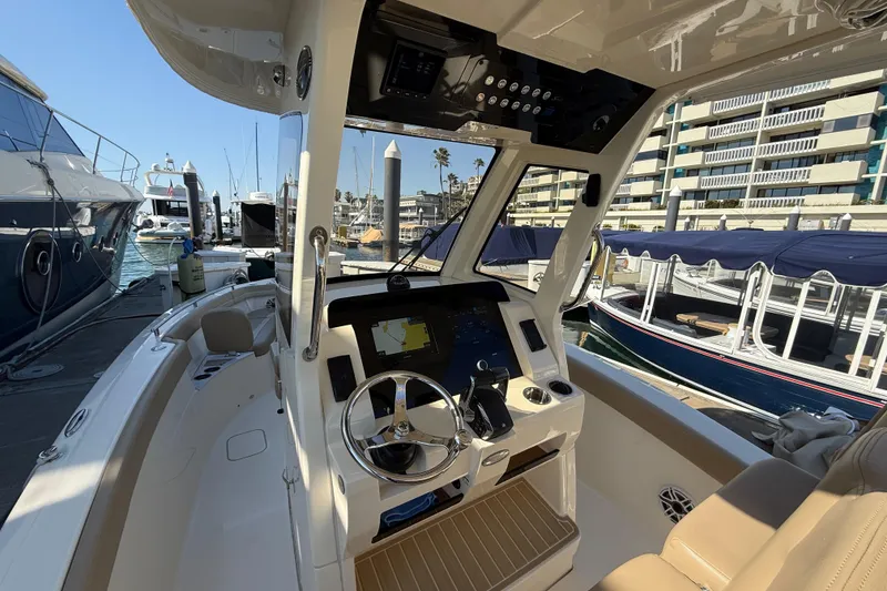 Slide: The Image of 2024 Scout 260 LXF boat interior at marina, featuring modern helm and controls. - 20