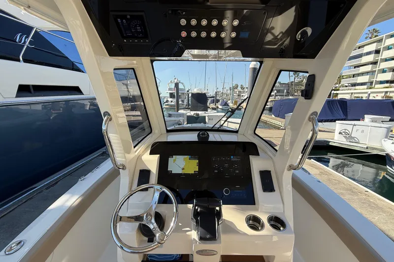 Slide: The Image of 2024 Scout 260 LXF boat helm with modern controls and navigation system at marina. - 21