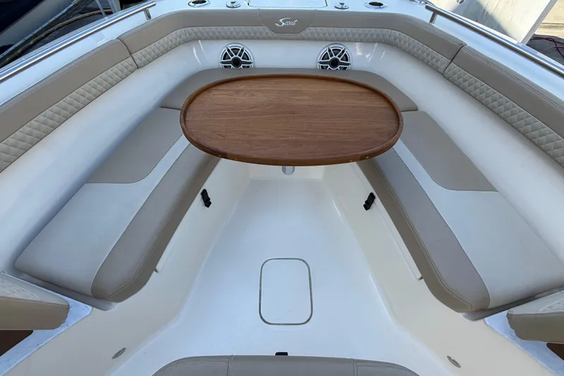 Slide: The Image of 2024 Scout 260 LXF boat interior with cushioned seating and wooden table. - 27