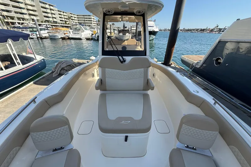 Slide: The Image of 2024 Scout 260 LXF boat interior at marina, showcasing seating and helm. - 30