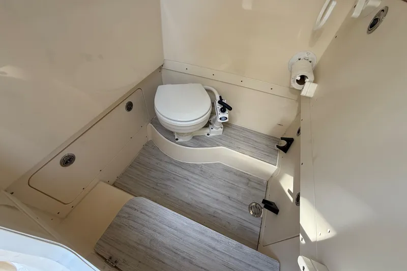 Slide: The Image of 2024 Scout 260 LXF boat interior bathroom with toilet and storage compartments. - 36
