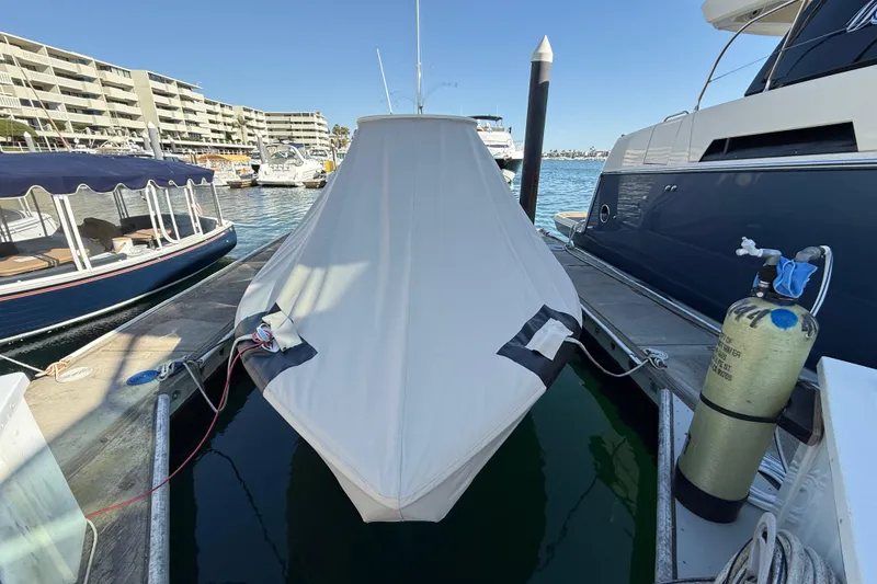 Slide: The Image of 2024 Scout 260 LXF boat covered at marina dock, surrounded by other boats. - 40
