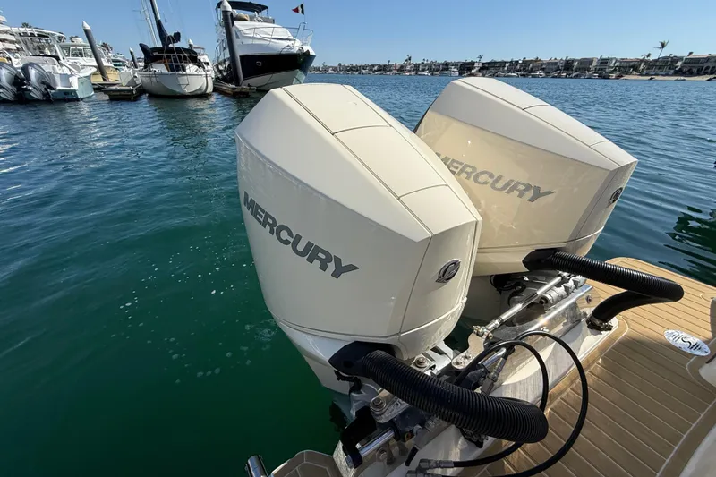 Slide: The Image of Twin Mercury engines on a 2024 Scout 260 LXF boat docked in a marina. - 8