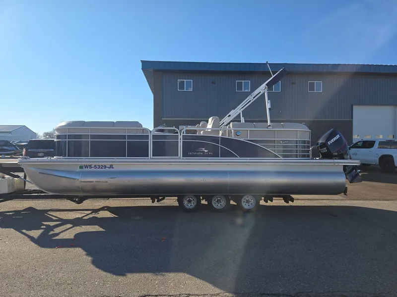 The Image of 2015 Bennington 2250 GSR pontoon boat on trailer in front of building. - 1