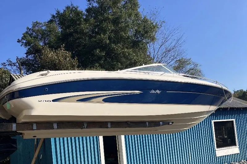 Slide: The Image of 2000 Sea Ray 230 Signature boat on display, blue and white design, outdoors. - 2