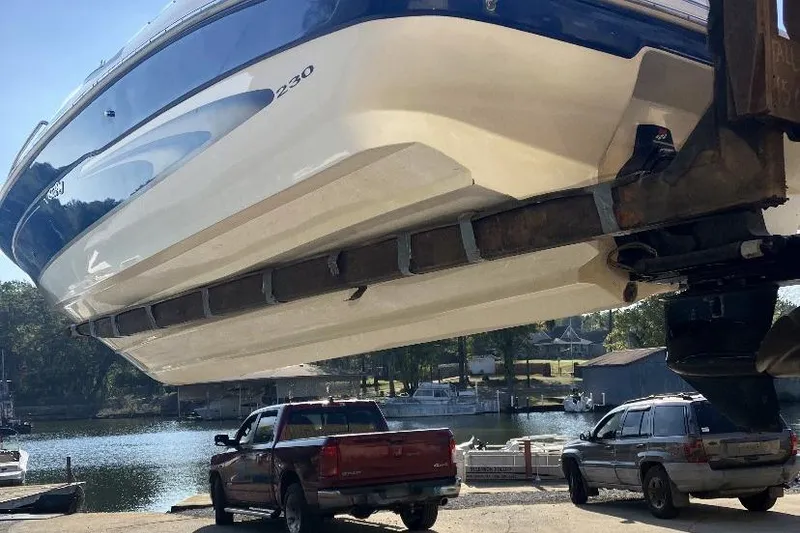 Slide: The Image of 2000 Sea Ray 230 Signature boat being lifted near a lakeside dock. - 3