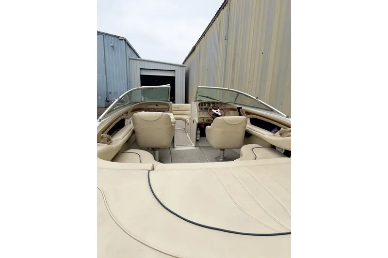 Slide: The Image of 2000 Sea Ray 230 Signature boat interior with beige seating and dashboard. - 5