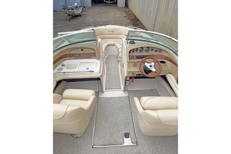 Slide: The Image of Interior of 2000 Sea Ray 230 Signature boat with beige seating and wooden steering wheel. - 6