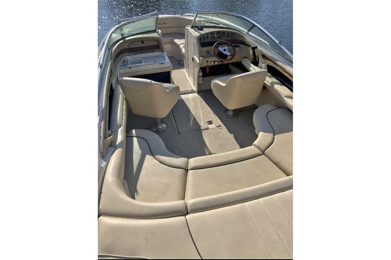Slide: The Image of 2000 Sea Ray 230 Signature boat interior with beige seating and steering wheel. - 7
