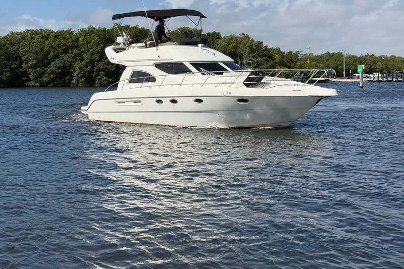 Slide: The Image of 2007 Cranchi Atlantique 40 yacht cruising on a calm river with lush greenery. - 1