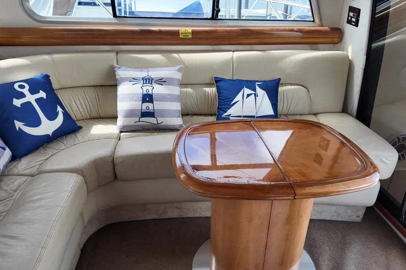 Slide: The Image of Luxurious 2007 Cranchi Atlantique 40 yacht interior with nautical-themed cushions and wooden table. - 10