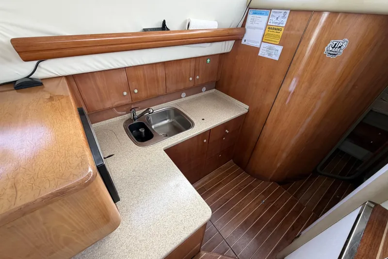 Slide: The Image of 2007 Cranchi Atlantique 40 yacht kitchen with wooden cabinetry and stainless steel sink. - 19