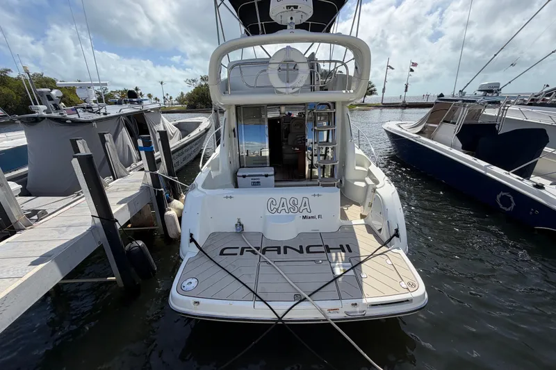 Slide: The Image of 2007 Cranchi Atlantique 40 yacht docked at marina, rear view with "CASA" nameplate. - 3