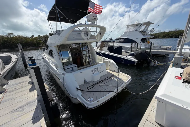 Slide: The Image of 2007 Cranchi Atlantique 40 yacht docked at marina, rear view with American flag. - 4