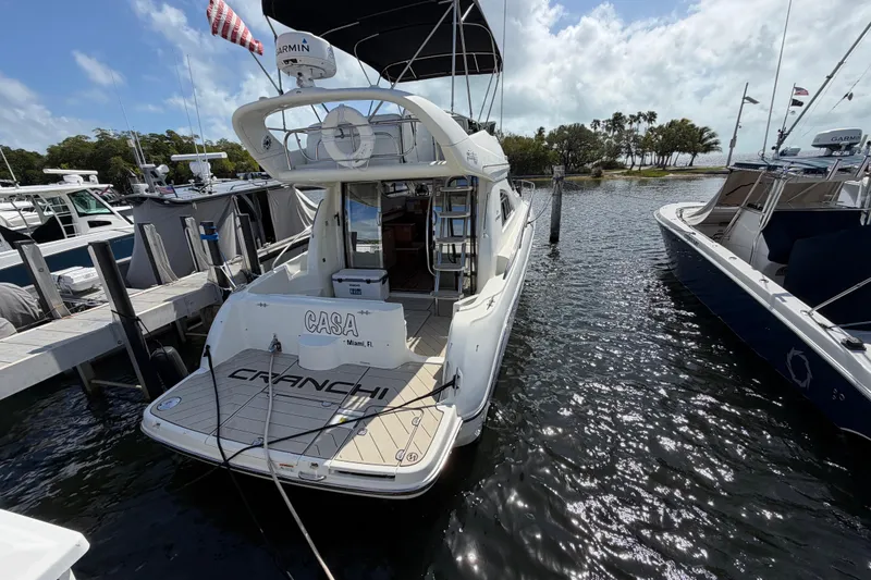 Slide: The Image of 2007 Cranchi Atlantique 40 yacht docked at marina, rear view with clear skies. - 5