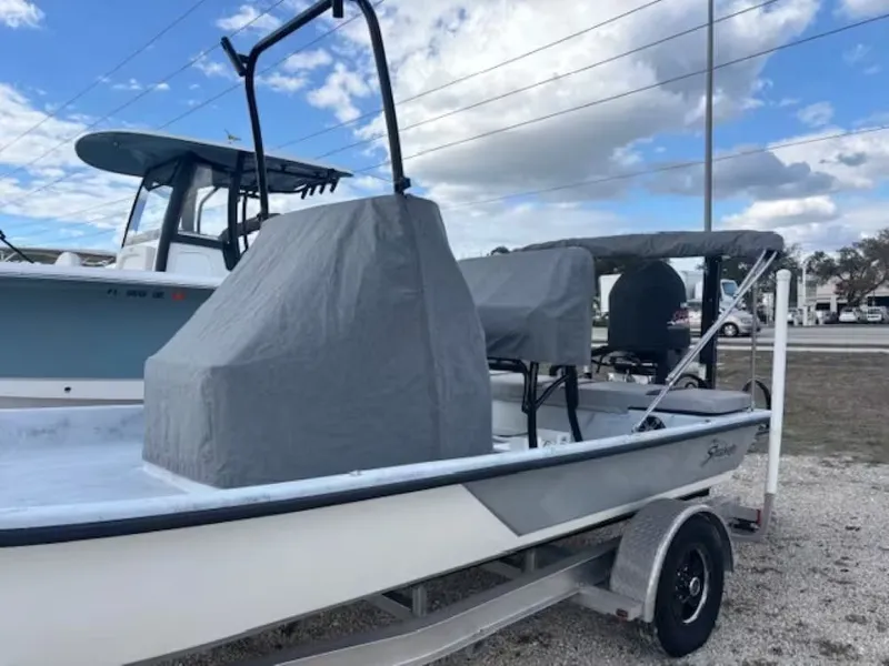 Slide: The Image of 2022 Shoalwater 20 CAT boat on trailer, covered, under blue sky. - 14